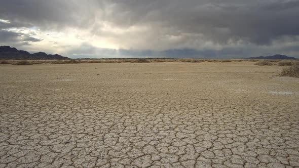 Panning over dry cracked earth in the desert Salt Flats in Utah alt