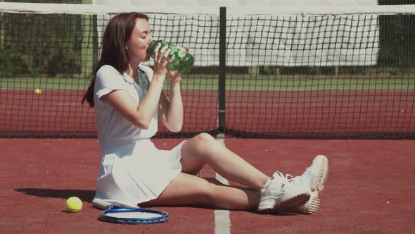 Female Tennis Player Drinking Water During Break