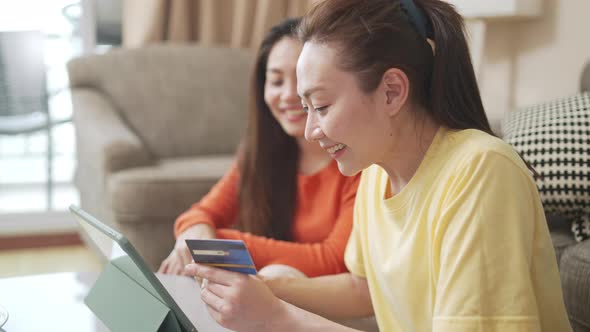4K Asian woman friends online shopping with credit card on digital tablet together