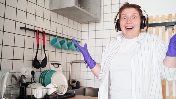 Young Happy Woman Wash Dishes at Kitchen