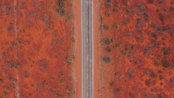Australian outback desert road top down aerial with red dirt, near Marla, South Australia alt