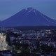 Night Cityscape Driving Cars on City Road on Background of Volcano. Time Lapse - VideoHive Item for Sale