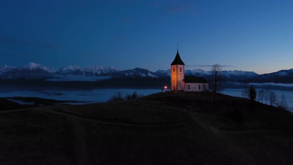 Church of St. Primoz and Felicijan in the Morning. Jamnik, Slovenia. Aerial View alt