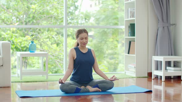 Young beautiful woman training yoga at home 