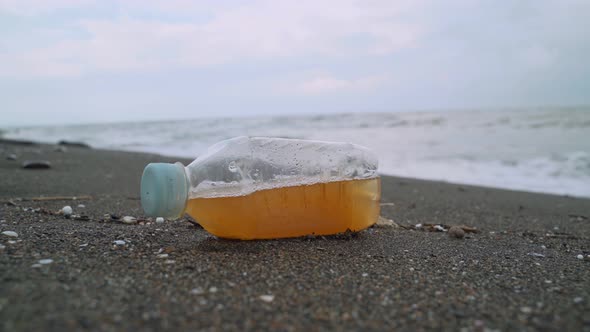 Anonymous Volunteer Removing Bottle With Beverage From Beach