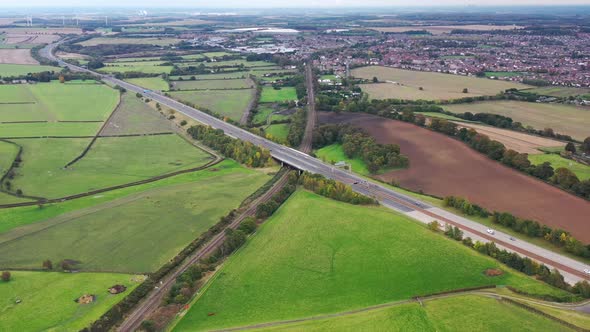Aerial footage of the M62 Motorway located in Leeds showing a train track going under the motorway