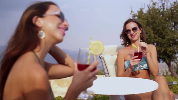 Young Multiethnic Women in Bikinis Enjoying Summer Cocktails in Nature