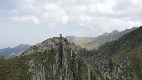 Man Standing on top of a Cliff in Rocky Mountains