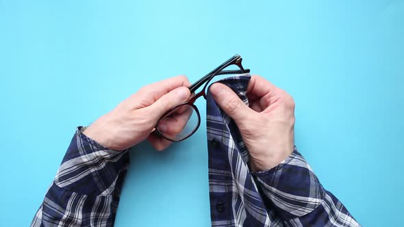 Man Wiping His Eyeglasses with His Shirt alt