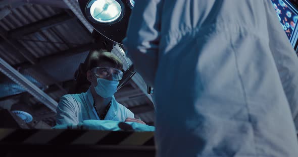 Scientist in a White Robe and Glasses Conducts a Scientific Experiment alt