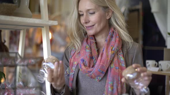 Mature woman choosing glass candles
