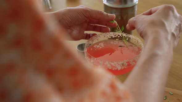 Woman with Shaker Pouring Cocktail Drink to Glass alt