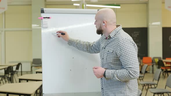 Teacher Records Mathematics Lessons He Stands and Writes with a Pen on a Flip Chart alt