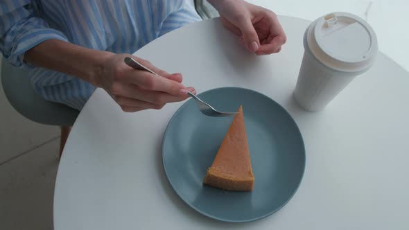 Woman at Cafe Drinking Hot Latteeating Cheesecake Slice alt