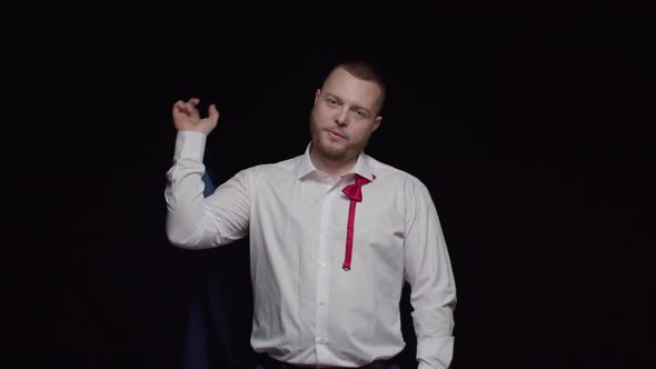 A Sexy Man with a Beard in a White Shirt Throws a Jacket Over His Shoulder and Smiles Against a alt