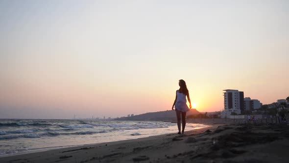 Young Woman on Summer Holidays Walking on Beach at Sunset