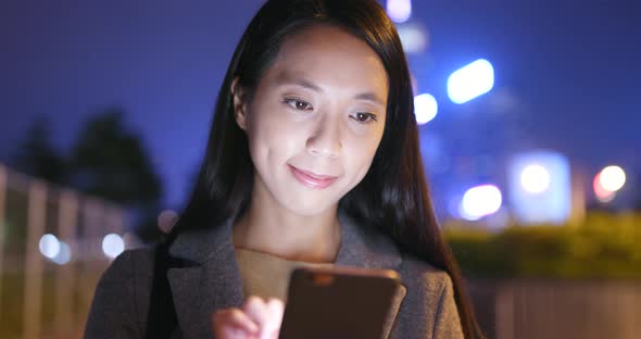 Young Woman use of mobile phone in Hong Kong at night alt