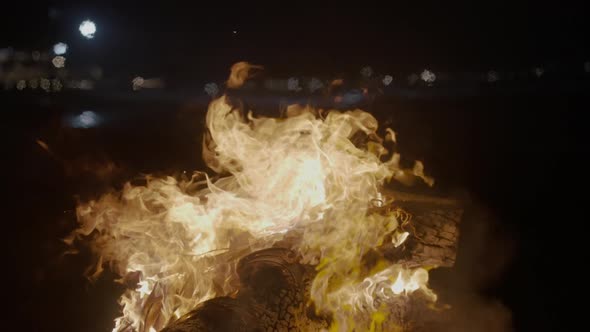 A Beautiful Slow Motion Beach Scene with Fire Flow on a Timber at Night