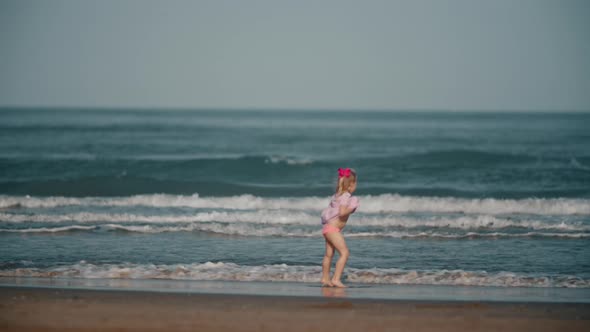 Happy Barefoot Child Playing with Ocean Waves alt