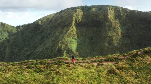 Man Walking on Road in Green Mountains Sao Miguel Island Azores Portugal alt