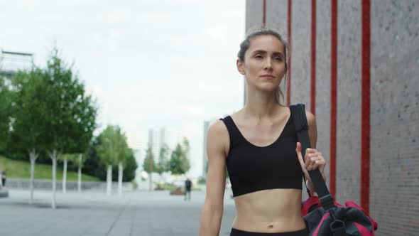Video of woman walking in a training outfit in the city. Shot with RED helium camera in 8K.  alt