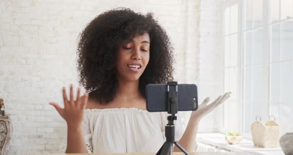 Sitting at Home a Young Mixedrace Woman Records a Video Webcast on Mobile Phone alt