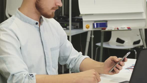 Handsome Young Bearded Businessman Using Smart Phone at Work alt