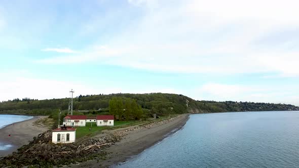 Drone shot flying past a lighthouse and towards the beach in Washington state. alt