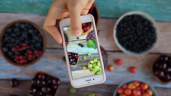 Blogger Shooting Stories of Smoothies with Chia Seeds and Berries on the Wooden Table alt