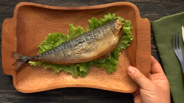 Top View of the Hands Placing Plate with a Delicious Juicy Grilled Red Char Fish alt