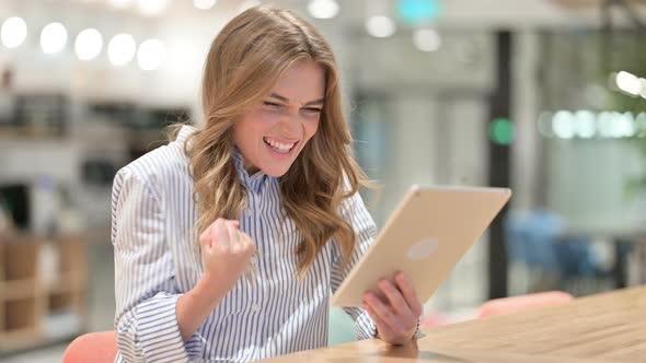 Excited Businesswoman Celebrating Success on Tablet alt