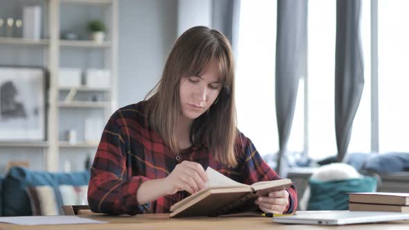 Casual Young Girl Reading Book in Creative Workplace alt