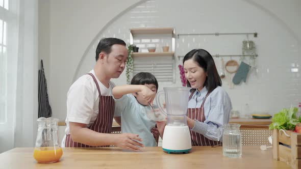 Asian family with father Mother and son helping to cook Making a smoothie in the kitchen