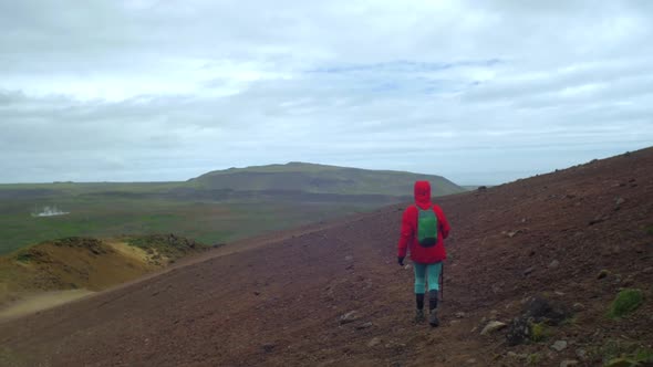 dramatic iceland landscape, person hiking on trail, krysuvik seltun area, camera following movmement alt