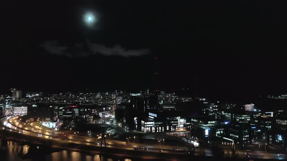 Drone Point of View of a Smoking Chimney in Helsinki on a Moonlit Night alt