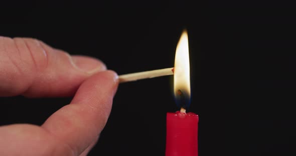 Hand firing a match from a candle alt