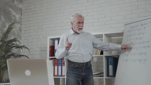 Confident Senior Male Teacher Conducts Online Classes in Contemporary Classroom alt