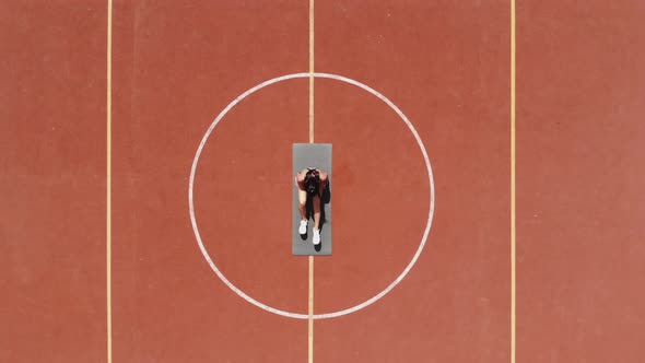 Aero, Top View, Fitness Woman in Sportswear Doing Various Exercises. Background of Orange Basketball alt