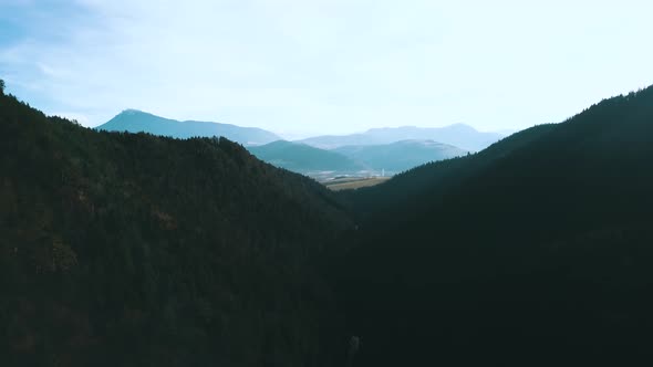 Drone shot over pine tree mountain valley with blue sky, Stock Footage