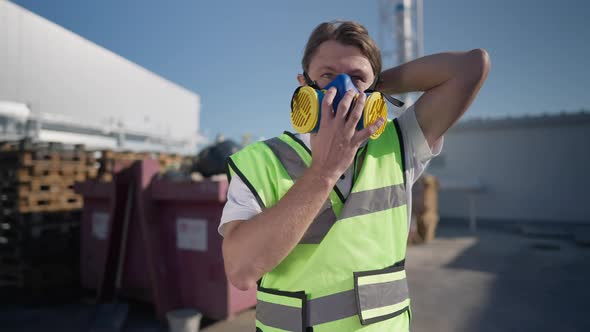 Portrait of Brunette Caucasian Adult Man Putting on Respirator Mask in Slow Motion Looking Around alt