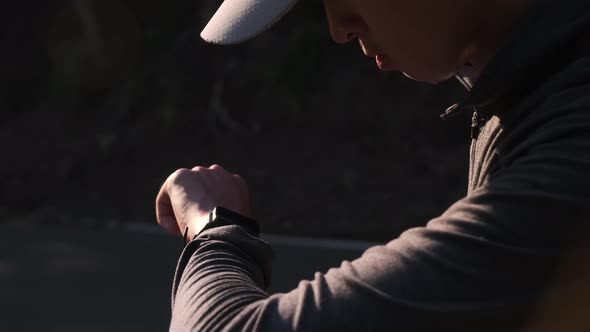 Healthy teenage boys looking at smart watch heart rate monitor.