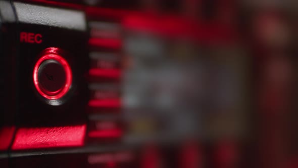 A Finger in a Black Glove Presses the Rec Button on the Camera in the Dark alt