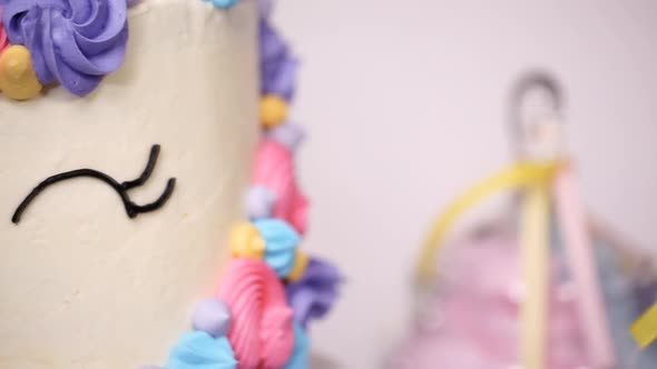 Close up of little girl's birthday party table with unicorn cake, cupcakes, and sugar cookies. alt