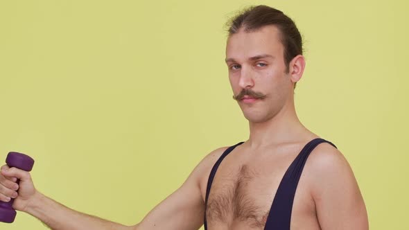 Strong Concentrated Man with Athletic Look Making Exercises with Dumbbell in Slow Motion alt