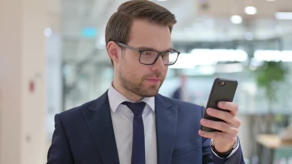 Excited Businessman Celebrating Success on Smartphone alt