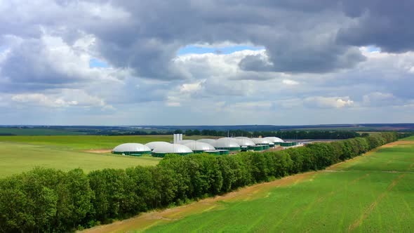 Storage and production of biogas, Aerial view of big biogas plant in green fields alt