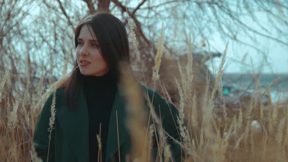 Young Brunette Among the Reeds with a Straw in Her Mouth