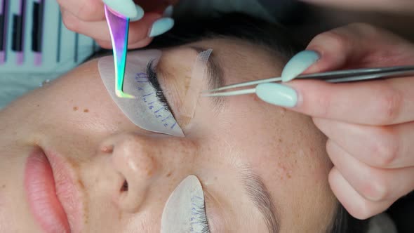 Eyelash Extension Master Straightens Client's Readymade Eyelashes with Tweezers alt