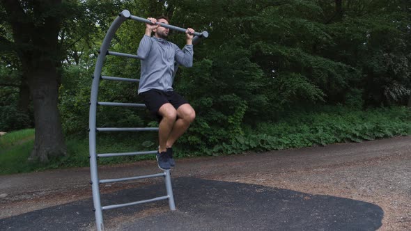 Athlete Using Chin-Up Bar In Forest Gym