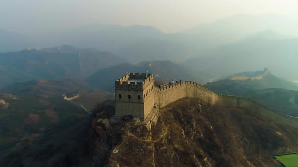 Great Wall of China and Green Mountains in Smog at Sunset. Badaling. Aerial View alt
